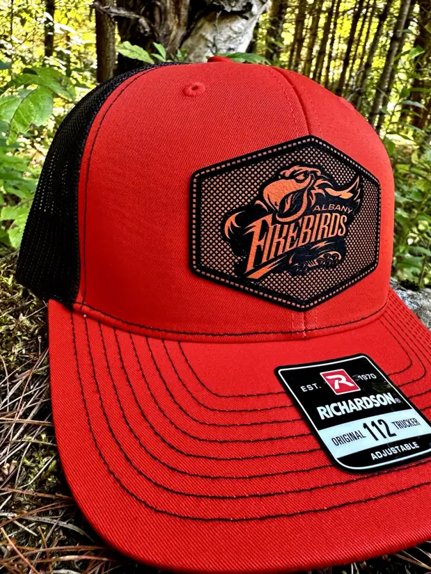 Albany Firebirds red and black patch hat photographed in the woods