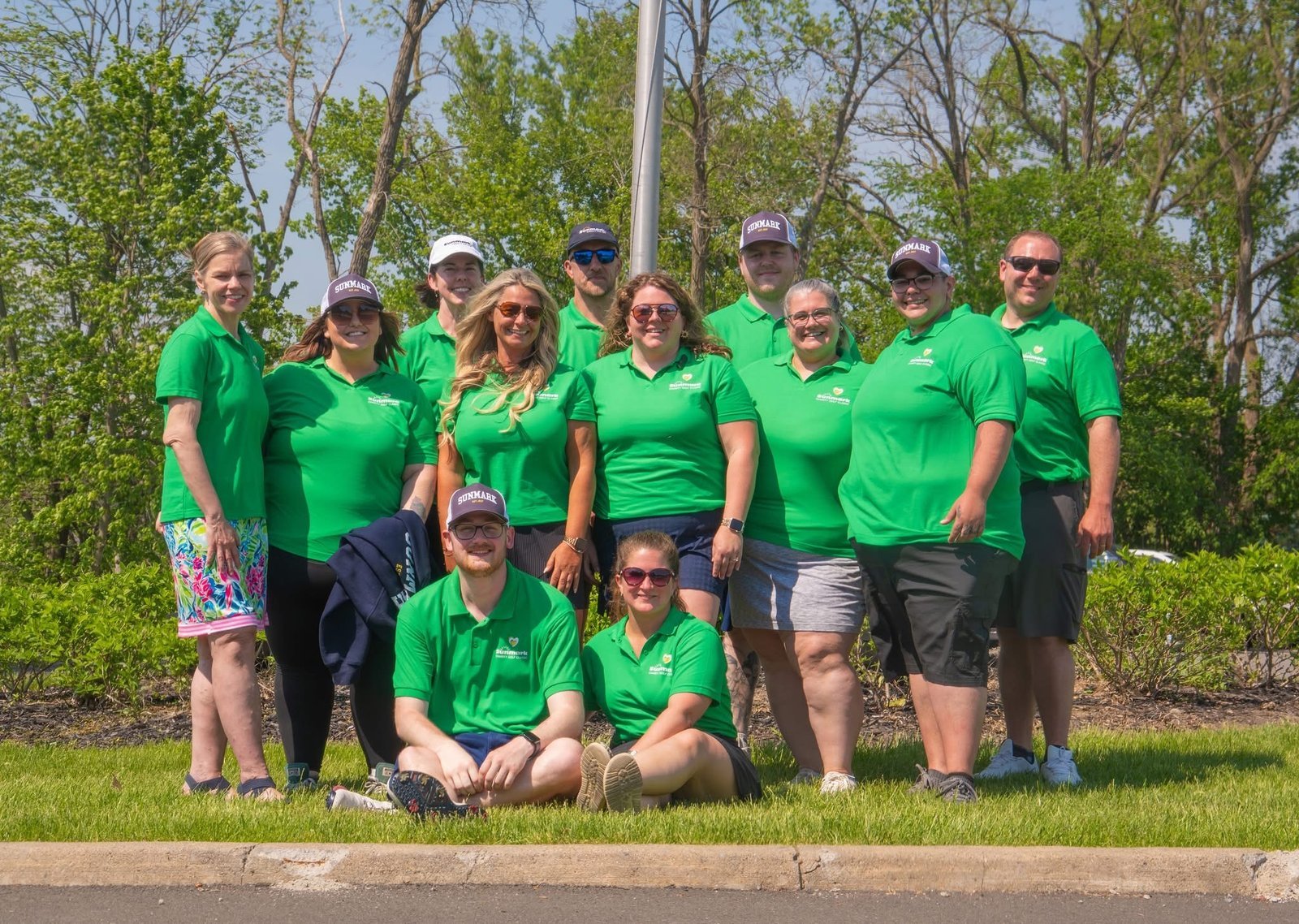 Sunmark group wearing matching green Charity Golf Classic polos