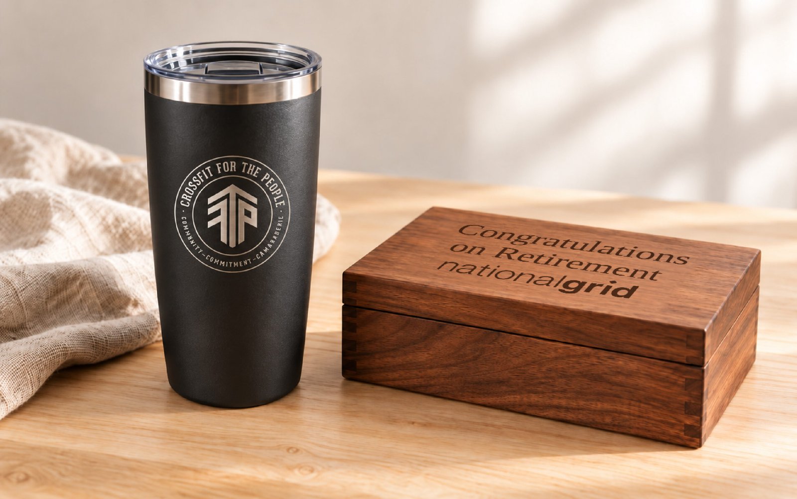 CrossFit For The People tumbler beside a wooden National Grid box engraved Congratulations on Retirement